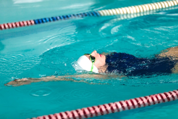 Swimmer performing backstroke in pool