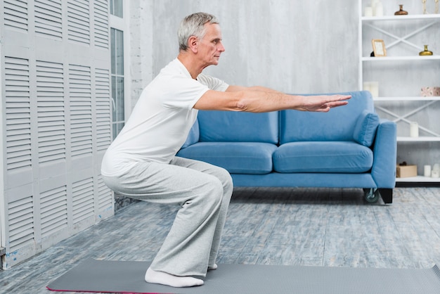 Senior performing chair squat with proper form