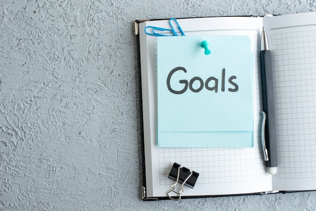 Person writing fitness goals in a journal