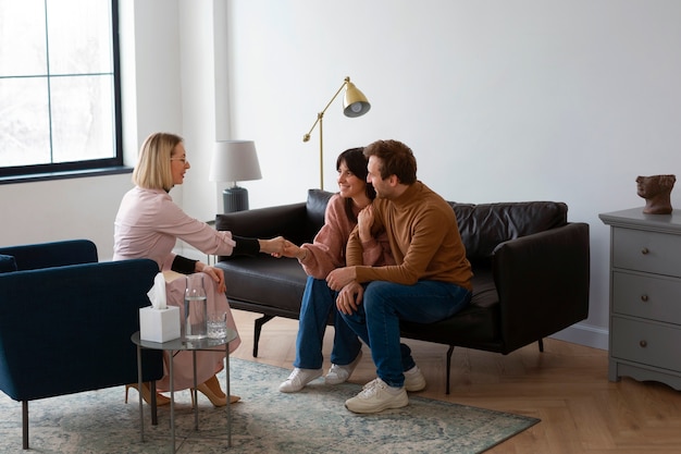 A couple sitting across from a therapist in a calm office setting
