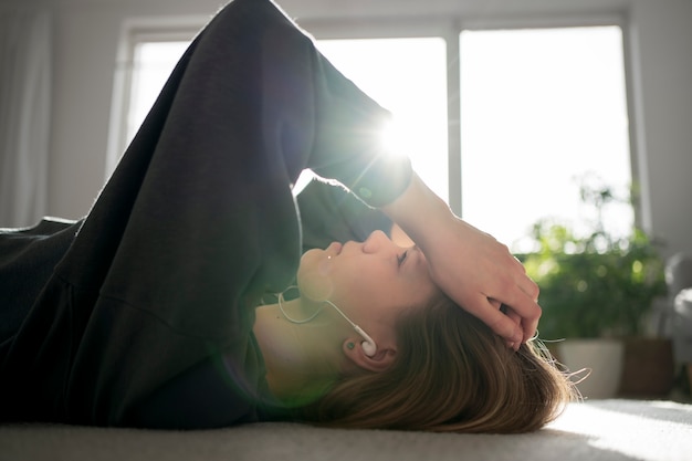 A woman sitting by the window, reflecting with a journal in hand