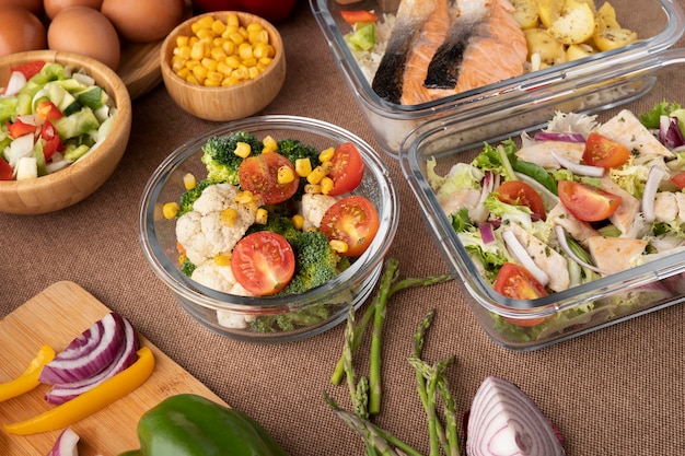 Hands preparing food in a clean kitchen with containers and fresh ingredients