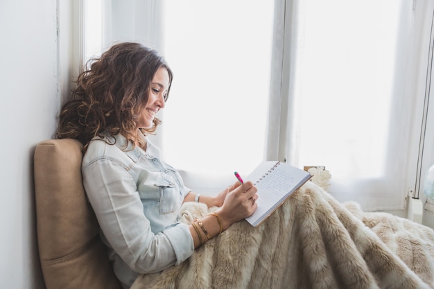 Woman tracking mood changes in a journal, representing bipolar disorder management